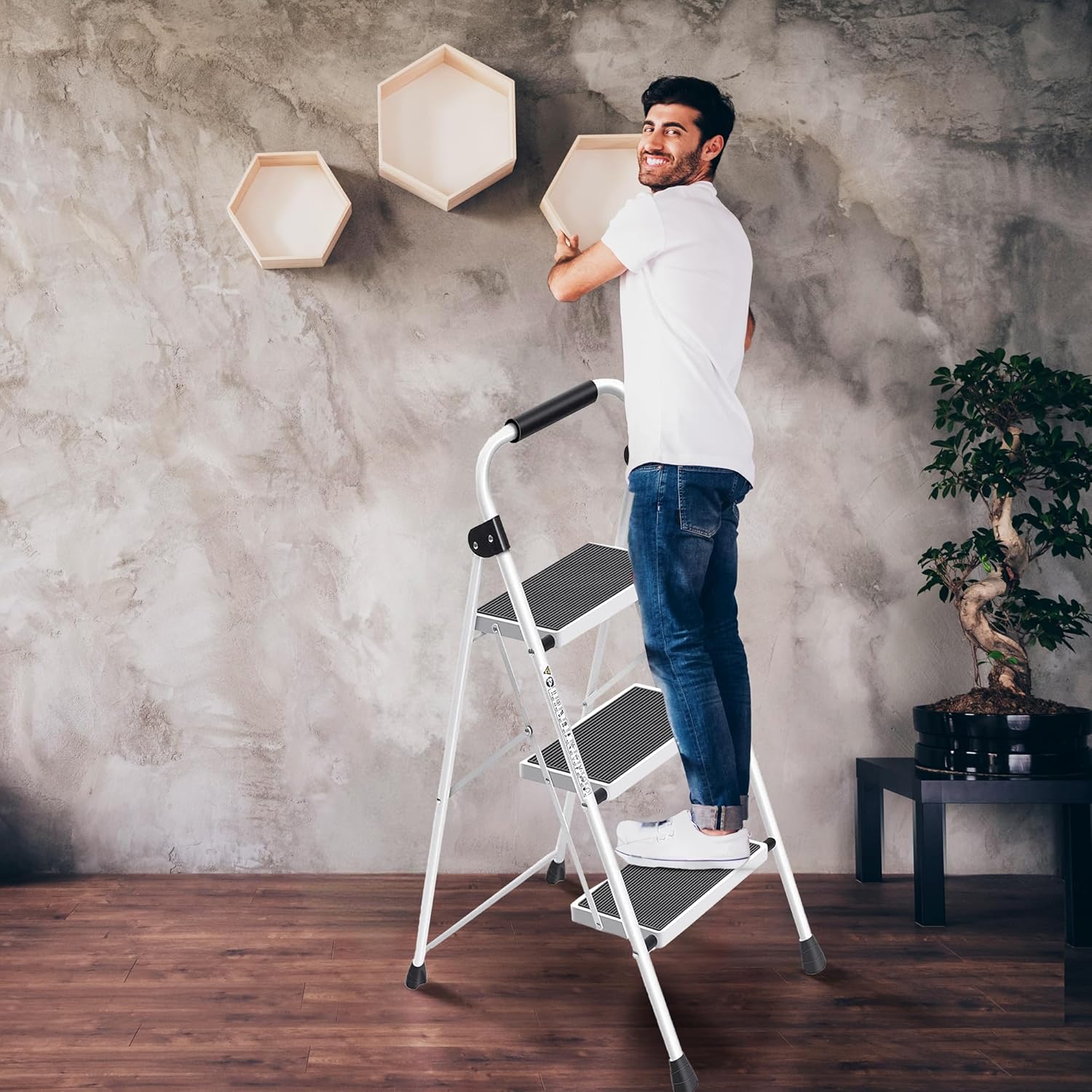A white 3-step folding ladder with black anti-slip pedals and bracing rods, shown in both open and closed positions.
